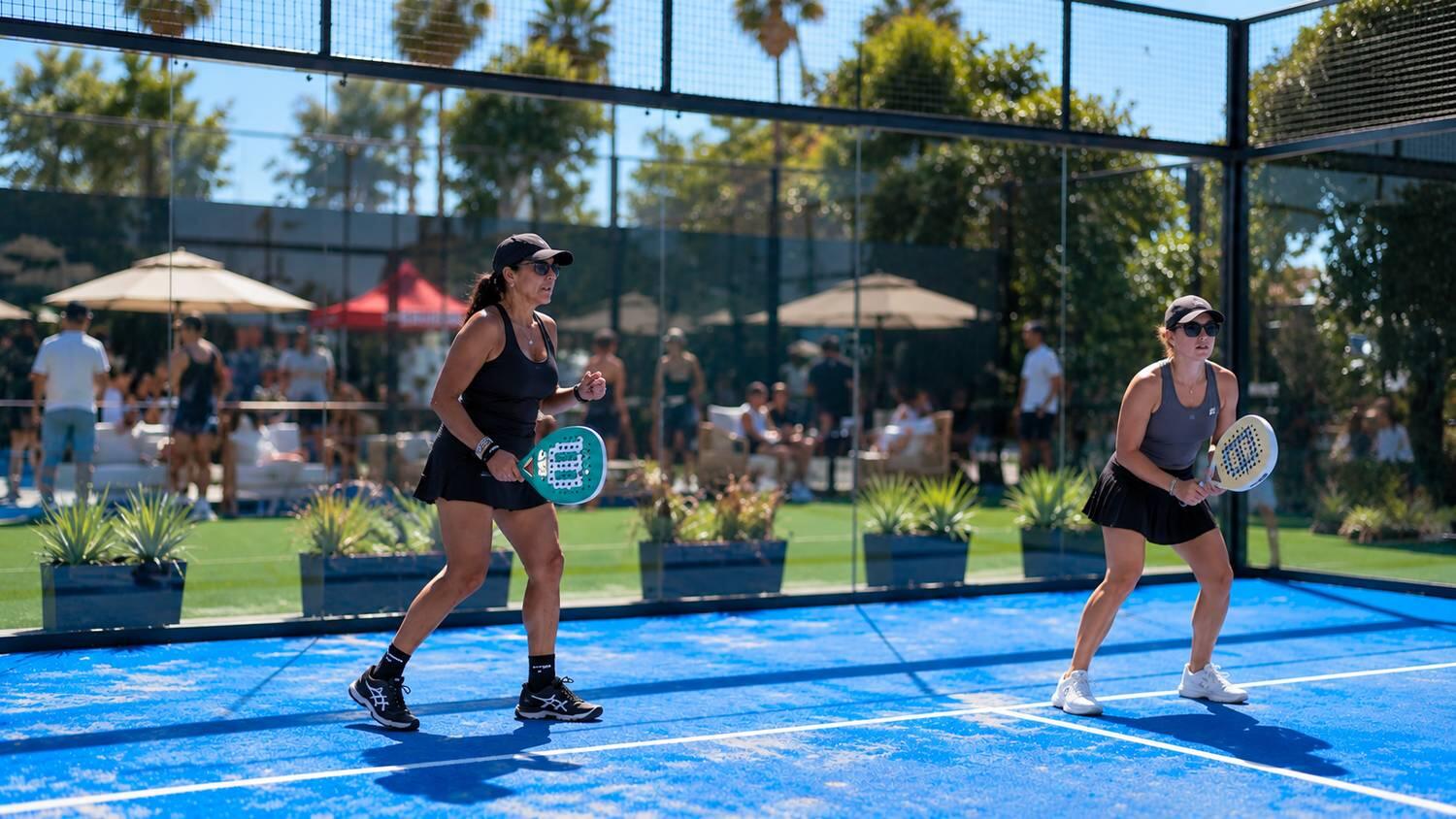Two players rallying on the padel court at TTC Newport Beach
